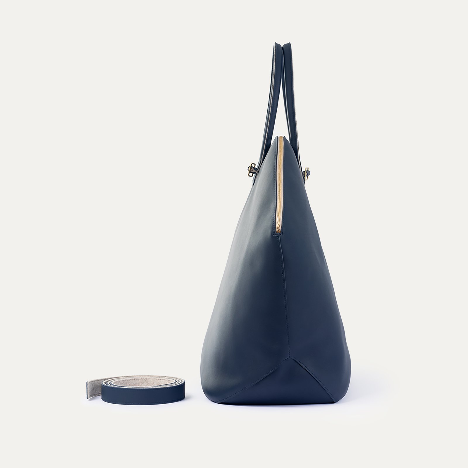 Sac de voyage Pecten Maximus INER en cuir marine, vue de profil avec bandoulière amovible