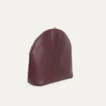 04 pochette iner bonbonniere main trois quart Pochette en cuir Bonbonnière lie de vin, vue trois-quarts