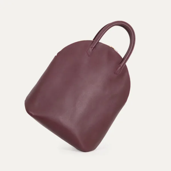05 sac voyage iner baluchon main sculptural Volume sculptural du sac Baluchon INER en cuir de veau lie de vin